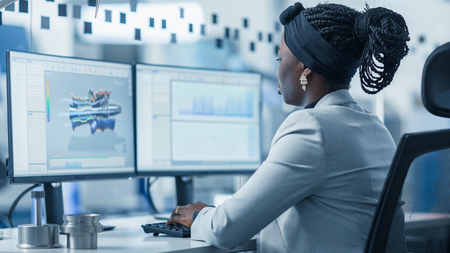 Beautiful Female Engineer Working on Personal Computer in the High-Tech Industrial Factory, She Uses CAD Software Designing 3D Turbine. Modern High-Tech Industrial Factory Office.