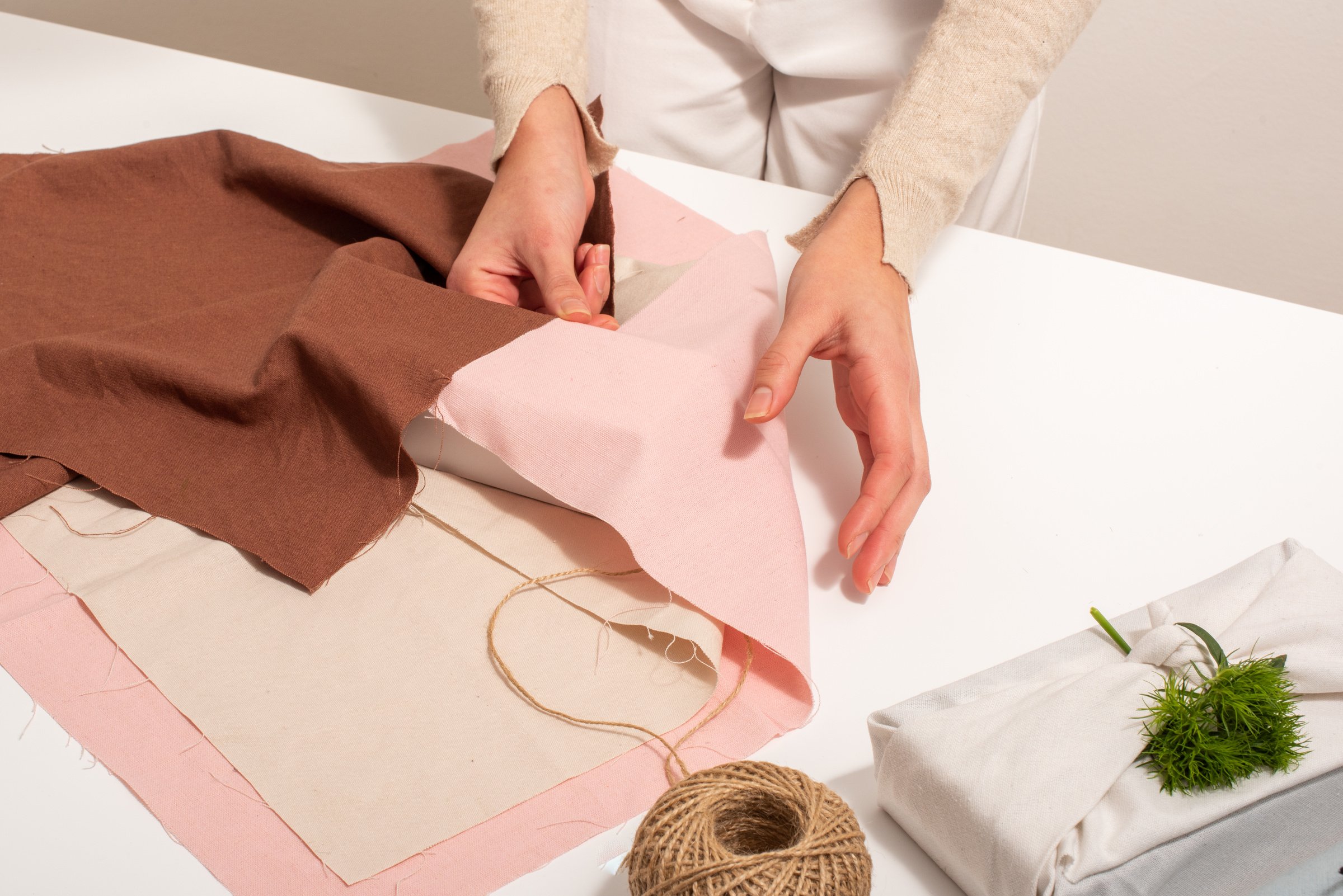 Woman Wrapping a Box Using Pink and Brown Fabrics